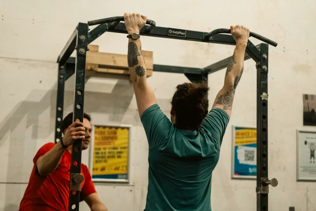 Personal trainer in Southampton teaching his client how to do pull ups